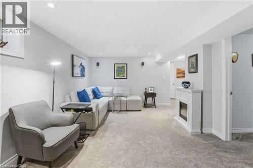 Living room with a glass covered fireplace, light colored carpet, and recessed lighting - 668 Tomahawk Crescent, Ancaster, ON - Indoor