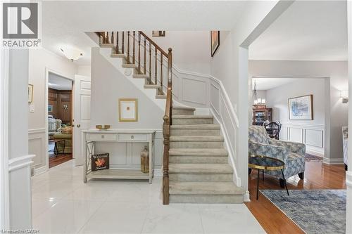 Stairs featuring a decorative wall, wainscoting, and wood finished floors - 668 Tomahawk Crescent, Ancaster, ON - Indoor Photo Showing Other Room