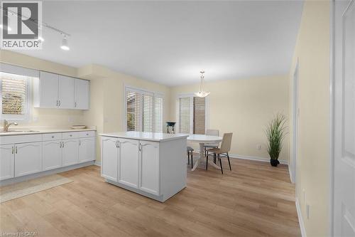 Kitchen with white cabinets, light countertops, light wood-style floors, and hanging light fixtures - 90 Westlawn Drive, Hamilton, ON - Indoor Photo Showing Kitchen