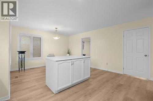 Kitchen with light countertops, white cabinets, light wood-type flooring, and decorative light fixtures - 90 Westlawn Drive, Hamilton, ON - Indoor Photo Showing Other Room