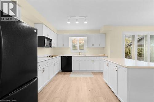 Kitchen featuring black appliances, white cabinets, light wood finished floors, light countertops, and a center island - 90 Westlawn Drive, Hamilton, ON - Indoor Photo Showing Kitchen