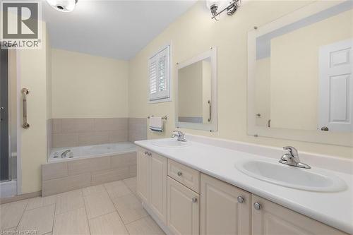 Bathroom featuring double vanity, tub, and light tile patterned floors - 90 Westlawn Drive, Hamilton, ON - Indoor Photo Showing Bathroom