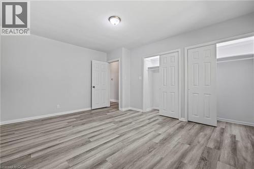 Unfurnished bedroom with light wood-style flooring and two closets - 40 Bertram Drive, Dundas, ON - Indoor Photo Showing Other Room