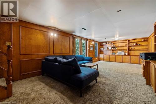 Living room featuring light colored carpet, wood walls, and built in features - 40 Bertram Drive, Dundas, ON - Indoor