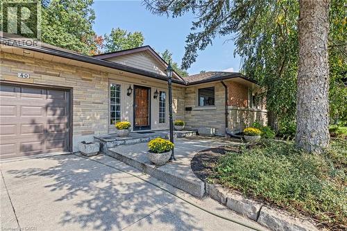 View of front of house featuring stone siding, a garage, and concrete driveway - 40 Bertram Drive, Dundas, ON - Outdoor