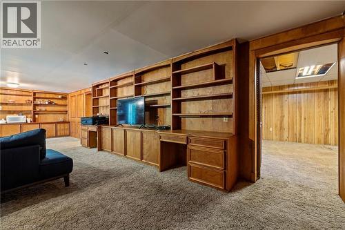 Living room with wood walls, carpet flooring, and built in desk - 40 Bertram Drive, Dundas, ON - Indoor