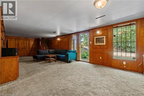 Living area featuring light carpet and wood walls - 40 Bertram Drive, Dundas, ON - Indoor Photo Showing Other Room
