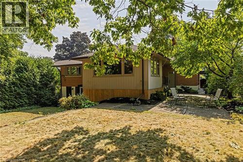 Rear view of property featuring a patio area, a yard, and brick siding - 40 Bertram Drive, Dundas, ON - Outdoor