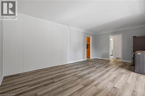Unfurnished living room featuring wood finished floors, washer / dryer, and crown molding - 40 Bertram Drive, Dundas, ON - Indoor Photo Showing Other Room