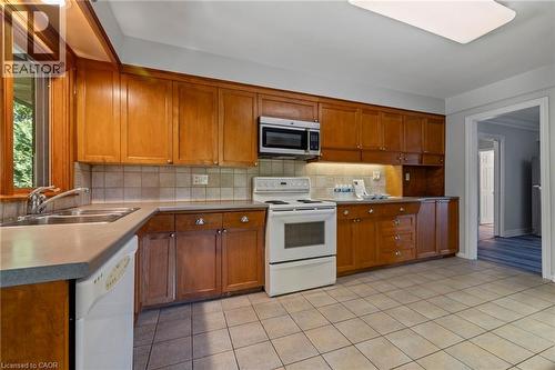 Kitchen with white appliances, wood finish cabinets, light countertops, and tasteful backsplash - 40 Bertram Drive, Dundas, ON - Indoor Photo Showing Kitchen With Double Sink