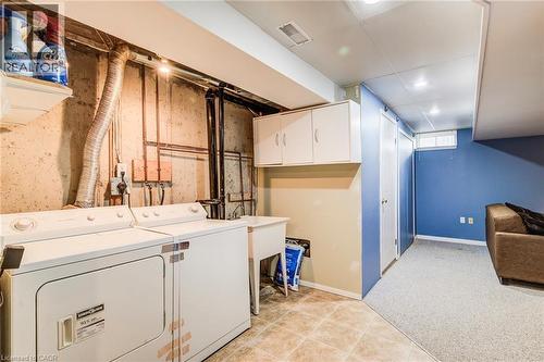 Laundry area with sink and storage cabinet. - 90 Mooregate Crescent Unit# 27, Kitchener, ON 