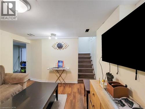 Living room featuring stairs and wood finished floors - 823 Queensdale Avenue E, Hamilton, ON - Indoor