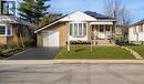 Stone facade home featuring a bay window, covered front porch, and solar panels - 823 Queensdale Avenue E, Hamilton, ON  - Outdoor 