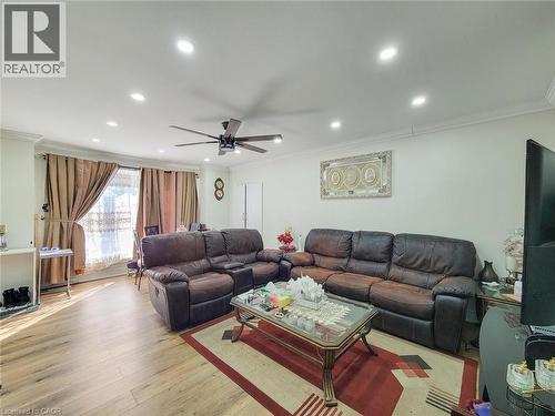 Bright living area featuring wood-finish flooring, recessed lighting, a ceiling fan, and crown molding - 823 Queensdale Avenue E, Hamilton, ON - Indoor Photo Showing Living Room