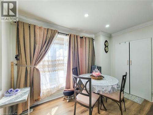 Dining area featuring wood-finish flooring, recessed lighting, crown molding, and a large window with privacy sheers and drapes - 823 Queensdale Avenue E, Hamilton, ON - Indoor Photo Showing Dining Room