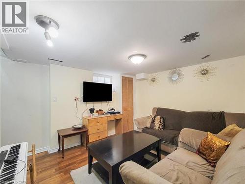 Finished lower level with wood-finish flooring, recessed lighting, and a window for natural light - 823 Queensdale Avenue E, Hamilton, ON - Indoor Photo Showing Living Room