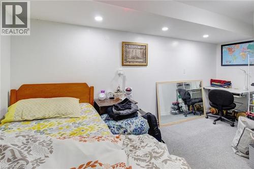 Carpeted room featuring a wooden headboard, recessed lighting, and white walls - 823 Queensdale Avenue E, Hamilton, ON - Indoor Photo Showing Bedroom