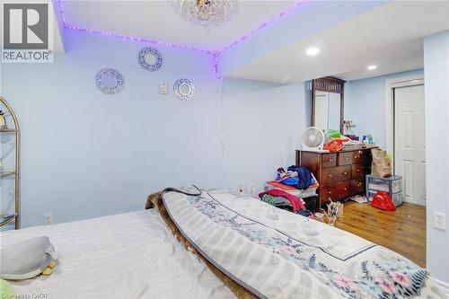 Room featuring light blue walls, recessed lighting, wood-finish flooring, and a white interior door - 823 Queensdale Avenue E, Hamilton, ON - Indoor Photo Showing Bedroom
