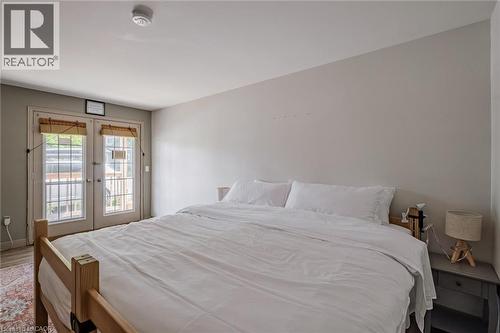 Bedroom featuring french doors, access to exterior, and wood finished floors - 30 John Street, Port Dover, ON 