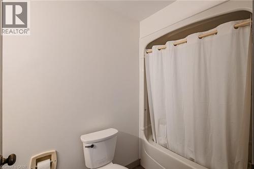 Bathroom featuring toilet and shower / bath combination with curtain - 30 John Street, Port Dover, ON 