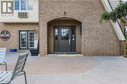 Property entrance featuring brick siding, a patio, and french doors - 