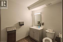 Half bathroom featuring vanity and dark wood-type flooring - 