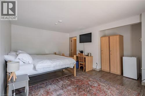 Bedroom featuring dark wood-style floors and white refrigerator - 30 John Street, Port Dover, ON 