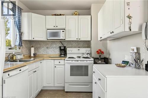 Kitchen with white appliances, white cabinets, and light countertops - 944 Garth Street, Hamilton, ON - Indoor Photo Showing Kitchen