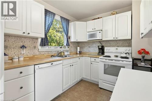 Kitchen featuring white appliances, white cabinetry, and light countertops - 944 Garth Street, Hamilton, ON - Indoor Photo Showing Kitchen