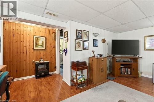 Living area with a paneled ceiling, wood finished floors, a wood stove, and wooden walls - 944 Garth Street, Hamilton, ON - Indoor