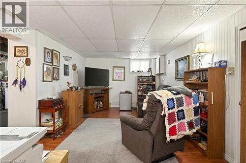 Living area with a paneled ceiling, wood walls, and wood finished floors - 944 Garth Street, Hamilton, ON - Indoor