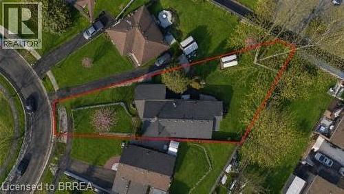 Large parcel featuring a single-story residence with a dark-shingle roof, extensive green lawn areas, mature trees, and a paved driveway leading to a circular road - 71 Pinecrest Drive, Kitchener, ON - Outdoor With View