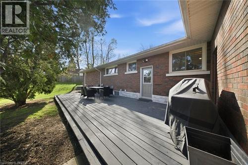 Expansive multi-level wood deck featuring a brick exterior, white trim windows, a rear entrance door, and a sloping green lawn - 71 Pinecrest Drive, Kitchener, ON - Outdoor With Deck Patio Veranda With Exterior