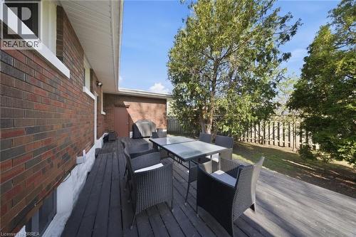 Expansive wood-finish deck bordered by a brick exterior and a privacy fence - 71 Pinecrest Drive, Kitchener, ON - Outdoor With Deck Patio Veranda With Exterior