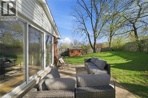Spacious backyard featuring a concrete patio, expansive lawn, and mature trees - 71 Pinecrest Drive, Kitchener, ON - Outdoor With Deck Patio Veranda