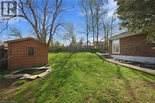 Expansive sloped lawn area with a wood-sided storage shed and a stone-edged pond - 71 Pinecrest Drive, Kitchener, ON - Outdoor