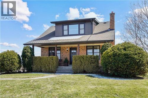 View of front of home with a front yard, covered porch, brick siding, and a shingled roof - 23247 Beattie Line, Elgin, ON - Outdoor