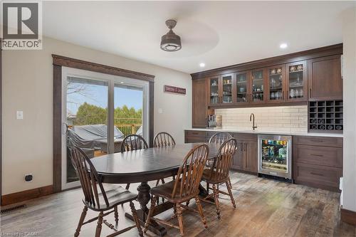 Dining room with beverage cooler, light wood-type flooring, recessed lighting, ceiling fan, and bar with sink - 23247 Beattie Line, Elgin, ON - Indoor Photo Showing Dining Room
