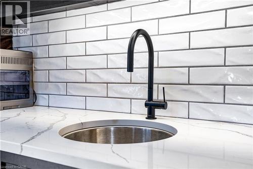 Kitchen view of a sink and light stone counters - 23247 Beattie Line, Elgin, ON - Indoor Photo Showing Garage