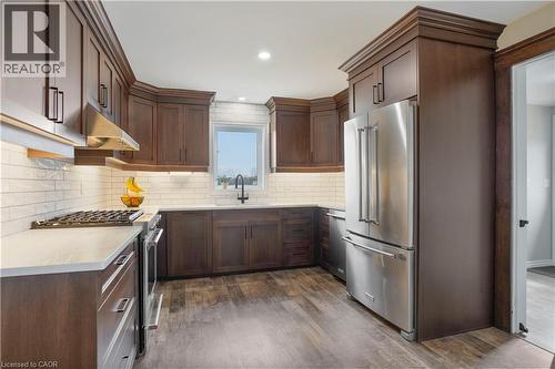 Kitchen featuring stainless steel appliances, dark wood-style flooring, light stone countertops, dark wood finish cabinets, and recessed lighting - 23247 Beattie Line, Elgin, ON - Indoor Photo Showing Kitchen With Upgraded Kitchen