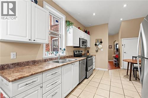 Kitchen featuring white cabinets, stainless steel appliances, light tile patterned floors, and recessed lighting - 78 Clyde Street, Hamilton, ON - Indoor Photo Showing Kitchen With Double Sink