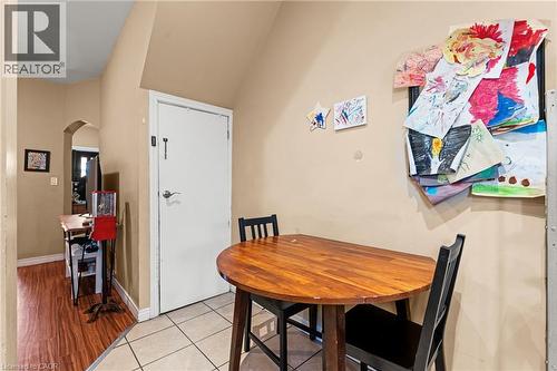 Kitchen featuring freestanding refrigerator, white cabinetry, open shelves, dark stone counters, and light tile patterned floors - 78 Clyde Street, Hamilton, ON - Indoor