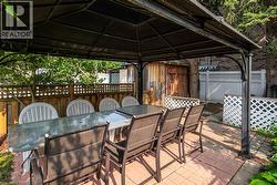 Fenced backyard with a gazebo, outdoor dining area, and a patio - 