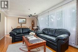 Living area with light wood-type flooring and a textured ceiling - 