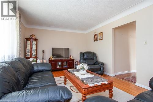 Living room with light wood-style flooring, a textured ceiling, and ornamental molding - 129 River Road E, Kitchener, ON - Indoor Photo Showing Living Room