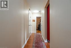 Hall with light wood-style flooring and baseboards - 