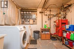 Laundry area featuring concrete flooring, electric panel, and washer and dryer - 