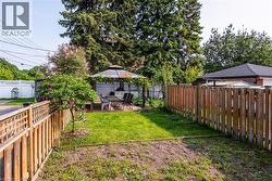 Fenced backyard featuring a gazebo and a patio area - 