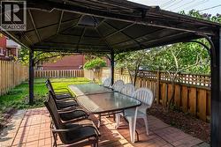 Fenced backyard with a gazebo, a patio, and outdoor dining space - 