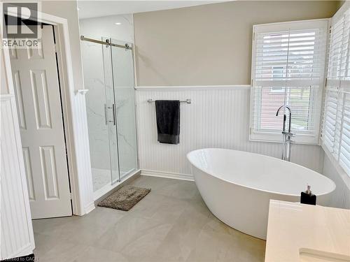 Bathroom featuring a wainscoted wall, a marble finish shower, and a freestanding tub - 2056 Hadfield Court, Burlington, ON - Indoor Photo Showing Bathroom